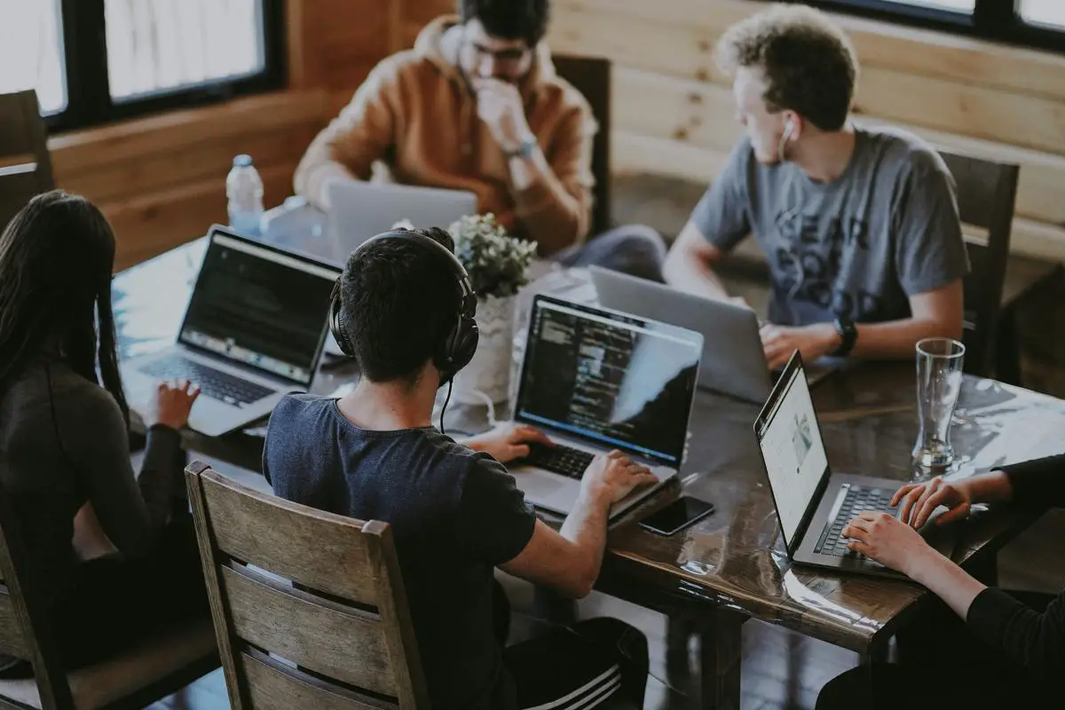 A team of diverse developers working on a single codebase for a web app that runs on multiple devices